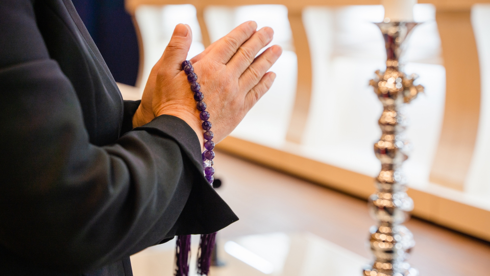 宇都宮市にある北関東互助センターで行われている葬儀で、念珠を手に合掌する遺族の手元