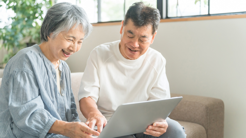 宇都宮市にある北関東互助センターについてタブレットで検索している高齢の夫婦の様子