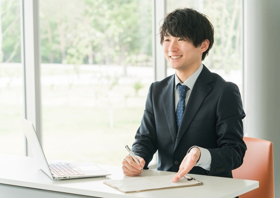 宇都宮市にある、北関東互助センターが事前相談をしている笑顔の男性スタッフの様子