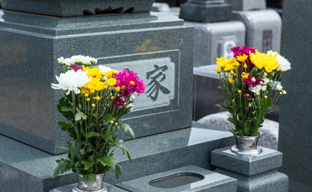 北関東互助センターが宇都宮市で供えた墓前に黄色と白の供花を置く風景